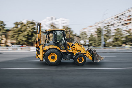 乌克兰，基辅 - 2021 年 7 月 16 日：灰色黄色 JCB 3CX 在街上行驶。