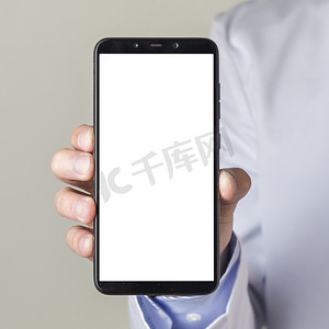 app展示摄影照片_特写男性医生的手展示带白屏显示的智能手机