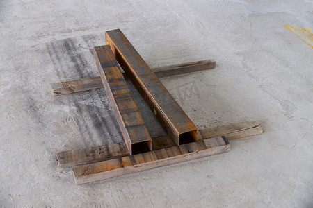 混凝土地板ne木板上的两根生锈金属方管