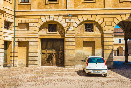 曼托瓦（曼图亚）- 2017年7月，意大利：白色小车停在圣巴巴拉广场公爵宫历史建筑附近