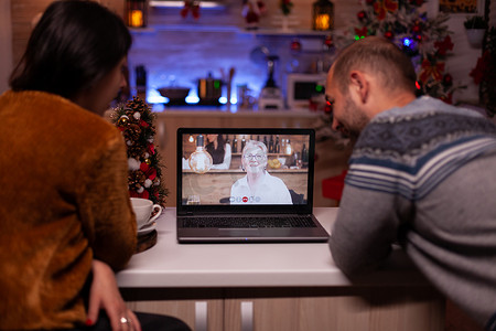 远程视频电话会议摄影照片_幸福的家庭在网上视频通话中与远程祖父母讨论