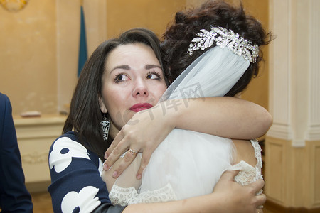 一名妇女一边流泪，一边向新娘表示祝贺。