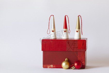 新年红色礼盒摄影照片_红色礼盒上的三个雪人