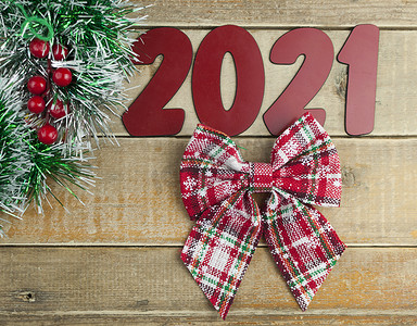 旧谷仓木板上的圣诞花环和 2021 年数字。