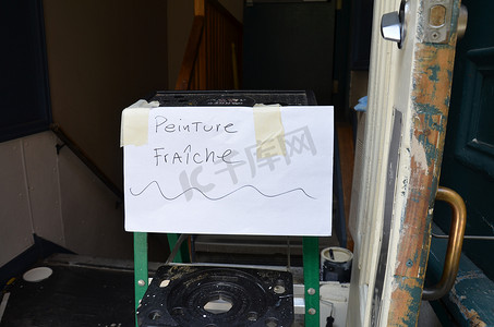 警告语摄影照片_纸上的湿油漆在梯子上用法语标牌