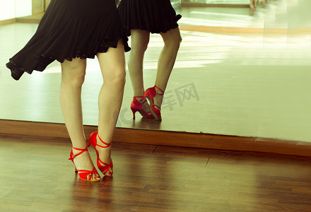 芭蕾舞女演员的腿与黑色裙子和红色鞋子的拉丁舞