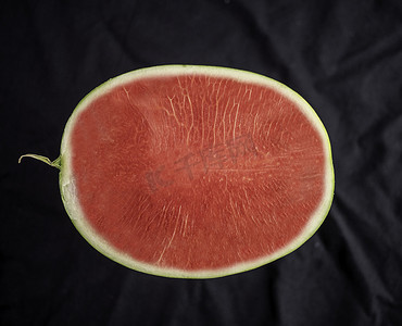 半球背景摄影照片_西瓜的顶视图，半球，鲜红色，无籽，放置在黑色背景上。