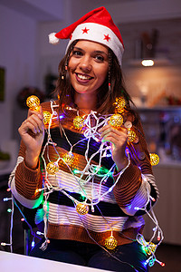 硅胶灯串摄影照片_快乐的成年人纠结在圣诞灯串中