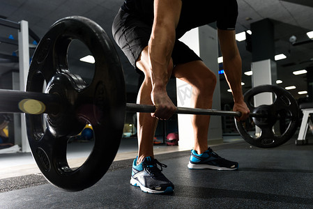 在健身房用杠铃举重锻炼的特写镜头。
