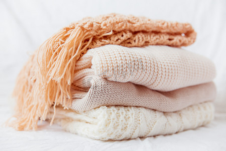 毛线团毛毛球摄影照片_白色背景上的一堆米色羊毛衣服。