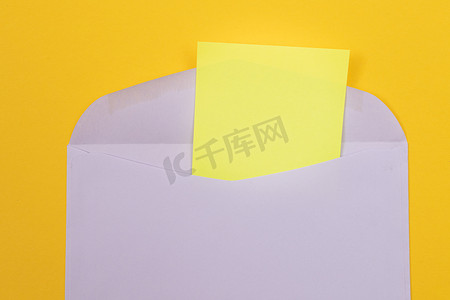 紫色邀请摄影照片_紫色信封，里面有一张空白的黄色纸