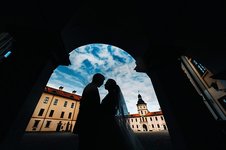 涅斯维日城堡背景下日落时一对相爱情侣的剪影