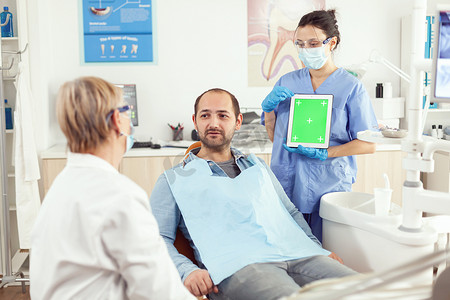 口腔科医生资深女性向患者解释牙痛