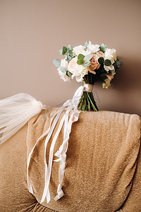 婚礼胸花摄影照片_椅子上有玫瑰的婚礼花束和胸花。婚礼上的装饰