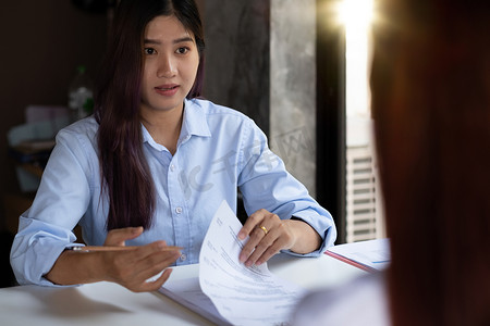 在公司会议或工作面试期间，女商人持有简历并与女性候选人交谈-商业、职业和安置概念。