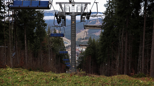 乌克兰，Bukovel - 2019 年 11 月 20 日。在秋季山坡和冬季滑雪胜地建设中的基础设施背景下，带缆车的滑雪胜地的秋季景色。