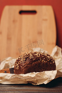 木桌纸包装上的黑麦面包锋利的刀红色背景板