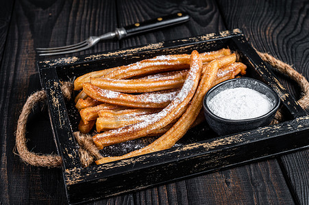 Churros 油炸棒用木托盘中的糖粉。