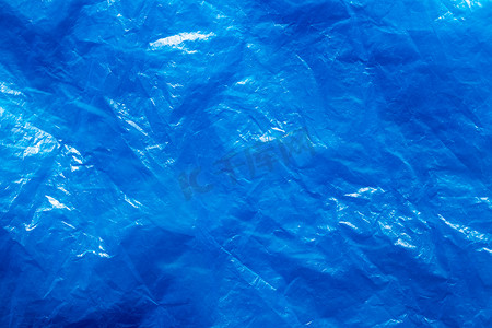 后退摄影照片_皱巴巴的蓝色塑料垃圾袋的纹理。