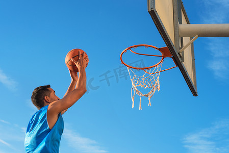 街头篮球运动员在球场上表演灌篮