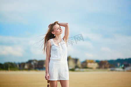 美丽的年轻女子在沙滩上享受阳光