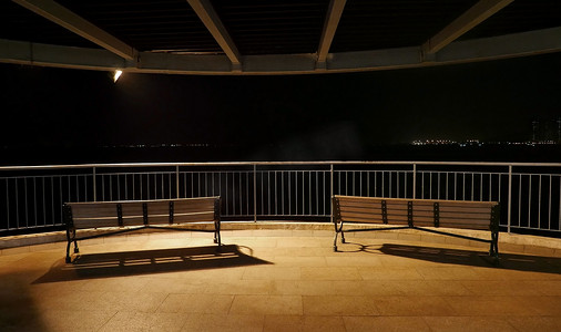 椅子阴影摄影照片_夜间公园里的户外家具木制海滩
