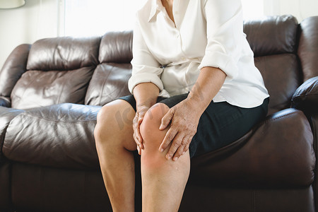 在家遭受膝盖疼痛的老年妇女，健康问题概念