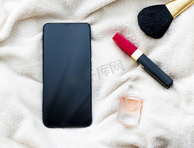 化妆小工具摄影照片_冬季白毯上的化妆和手机、智能手机平面模型作为应用程序模板和品牌营销设计