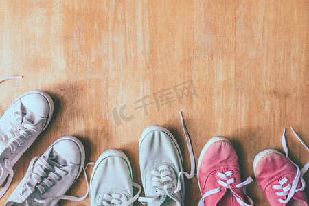衣服平铺摄影照片_木桌背景上彩色运动鞋的顶视图。