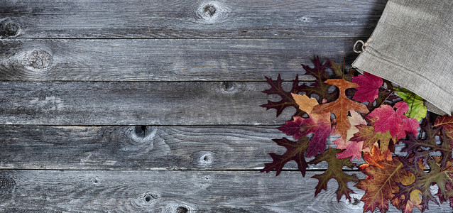 粗麻布袋，在质朴的木板上装有干叶，用于秋季系列