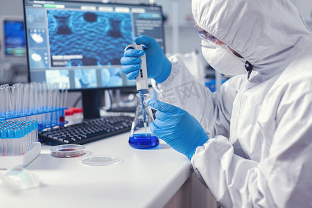 微吸管摄影照片_科学实验室中使用微移液器和培养皿的人