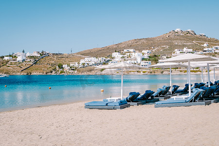 泽莉摄影照片_Ornos 海滩 Mykonos 岛，著名的 Ornos 海滩，在希腊基克拉泽斯岛的 Mykonos 岛设有日光浴床，翡翠清澈的 Ornos 海滩
