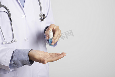 医生使用喷雾酒精清洁手来保护抗病毒细菌。