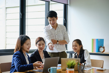 女商人和会计师小组在数字平板电脑上检查数据文件以调查腐败账户。