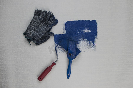 滚筒刷漆，工人在表面墙漆公寓上刷漆，用深蓝色油漆进行翻新。