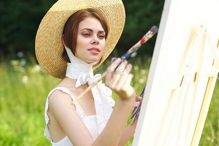 穿白裙的女人艺术家在自然调色板上作画创意