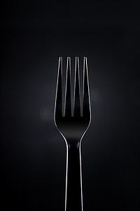 深色背景上的黑色塑料叉子