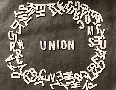 联合国际摄影照片_在仿古纸背景上的木制立方体字母表字母顶部视图中的联合词。