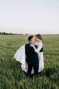 新郎新娘走在麦绿的田野上