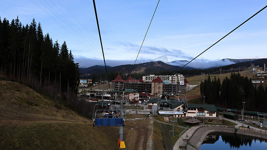 乌克兰，Bukovel - 2019 年 11 月 20 日。在秋季山坡和冬季滑雪胜地建设中的基础设施背景下，带缆车的滑雪胜地的秋季景色。