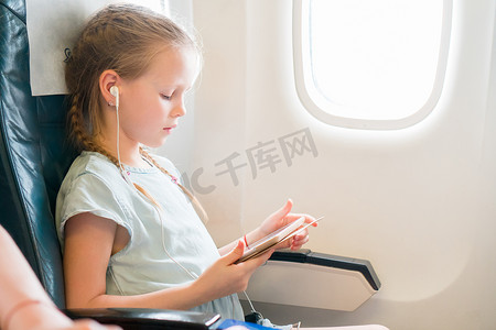 可爱的小女孩乘飞机旅行。