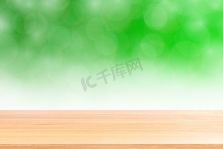 空木桌地板在模糊的散景软绿色渐变背景上，木板空在绿色散景彩色光罩上，彩色散景灯渐变软，用于横幅广告产品
