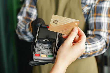 无接触摄影照片_客户使用信用卡在咖啡馆或商店通过具有 nfc 无现金技术的终端付款