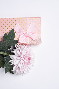 礼盒绿色摄影照片_粉色礼盒鲜花花束节日浅色背景