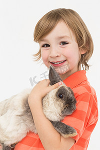 快乐男孩抱着毛茸茸的兔子的肖像