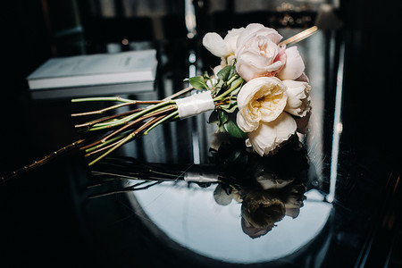 与玫瑰和胸花的婚礼花束。婚礼上的装饰