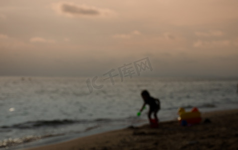 快乐的孩子在夏天肖像的海滩上玩沙子。