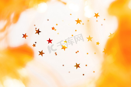 假日背景与金色和红色的星星五彩纸屑，闪亮的灯泡。