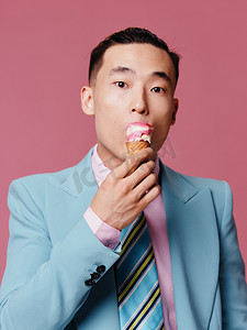 韩国经典摄影照片_身穿蓝色经典西装、冰淇淋肖像粉色背景模型特写的男子