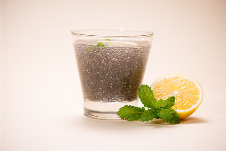 奇亚籽在透明玻璃杯中加水和柠檬香脂的选择性焦点。